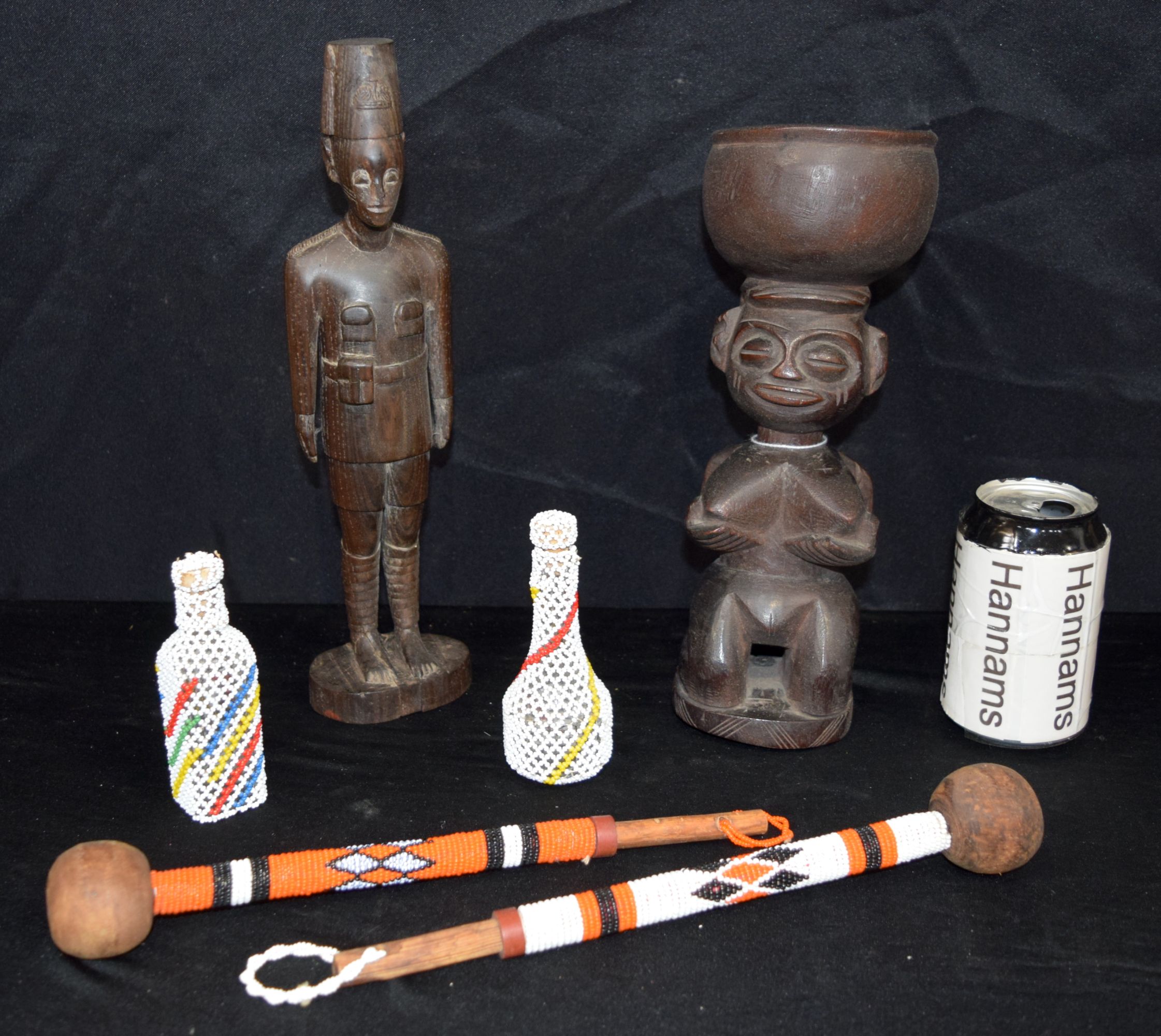 An African wooden figure of a Colonial soldier, together with another wooden figure & a quantity of