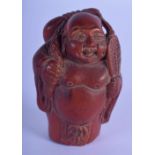 A JAPANESE WOOD NETSUKE CARVED AS A BUDDHA WITH A SACK ON HIS BACK. 3.8cm wide, 6cm high, weight 36