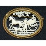 A small carved ivory brooch depicting a coach & horses. 5cm