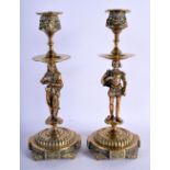 A PAIR OF 19TH CENTURY EUROPEAN BRASS CANDLESTICKS decorated with figures. 25 cm high.