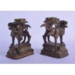A PAIR OF 19TH CENTURY SOUTH EAST ASIAN BRONZE CANDLESTICKS formed as roaming beasts. 7 cm x 9 cm.