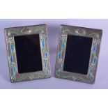 A PAIR OF ART NOUVEAU STYLE SILVER AND ENAMEL PICTURE FRAMES. 19.5cm x 14.7cm (2)