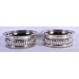 A PAIR OF ANTIQUE CONTINENTAL SILVER BOTTLE COASTERS of ribbed form. 628 grams overall. 15 cm x 5 cm