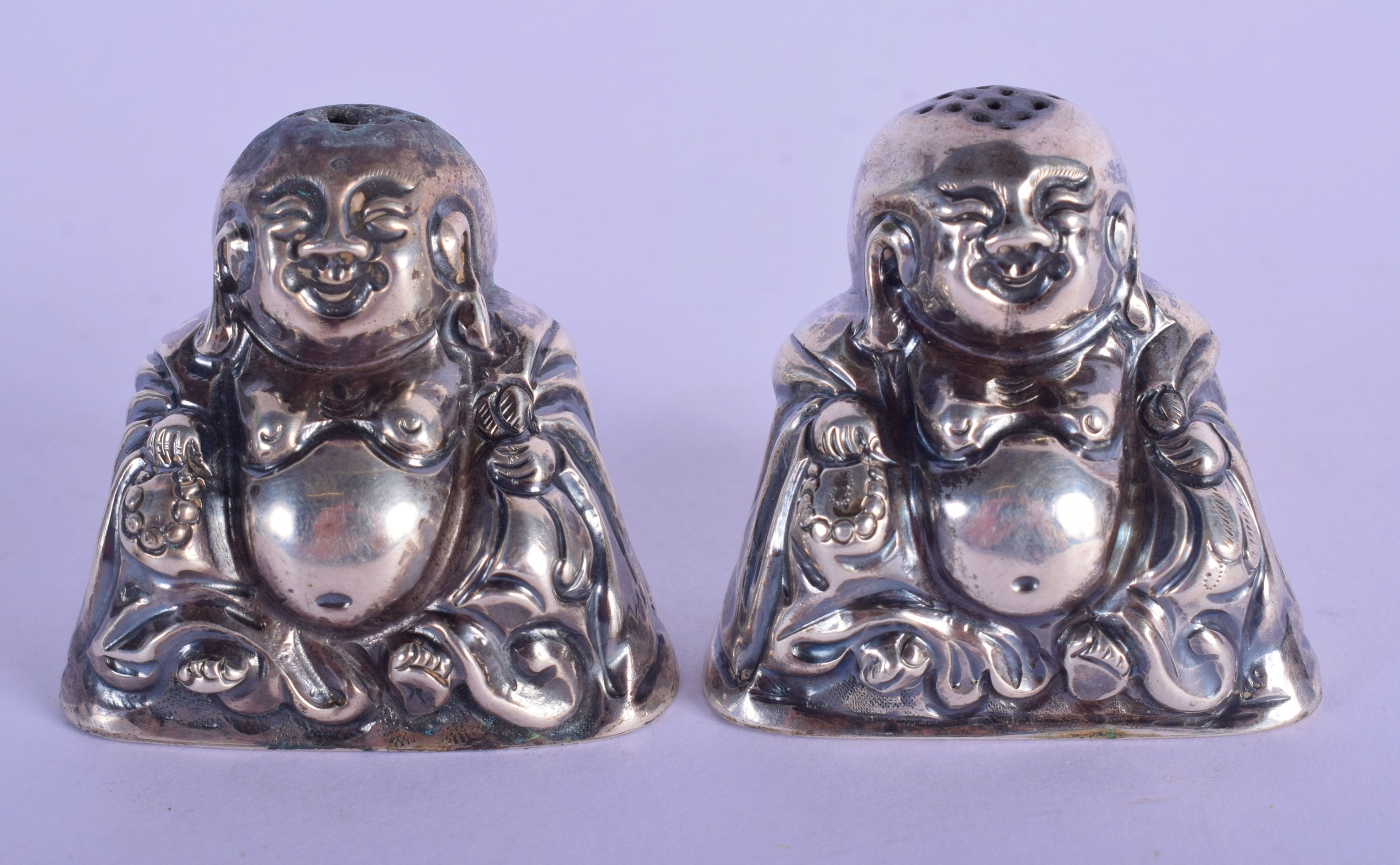 A PAIR OF CHINESE SILVER CONDIMENTS IN THE FORM OF BUDDHA. 4cm x 4.5cm x 2.5cm, weight 43g
