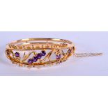 A 9CT GOLD BANGLE INSET WITH AMETHYSTS. 5.5cm x 5cm. Weight 9g