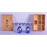 A JAPANESE TAISHO PERIOD PORCELAIN SAKE SET painted with flowers. Largest 9 cm high.