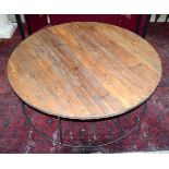 A large round pine table set on a metal base 43 x 124cm.