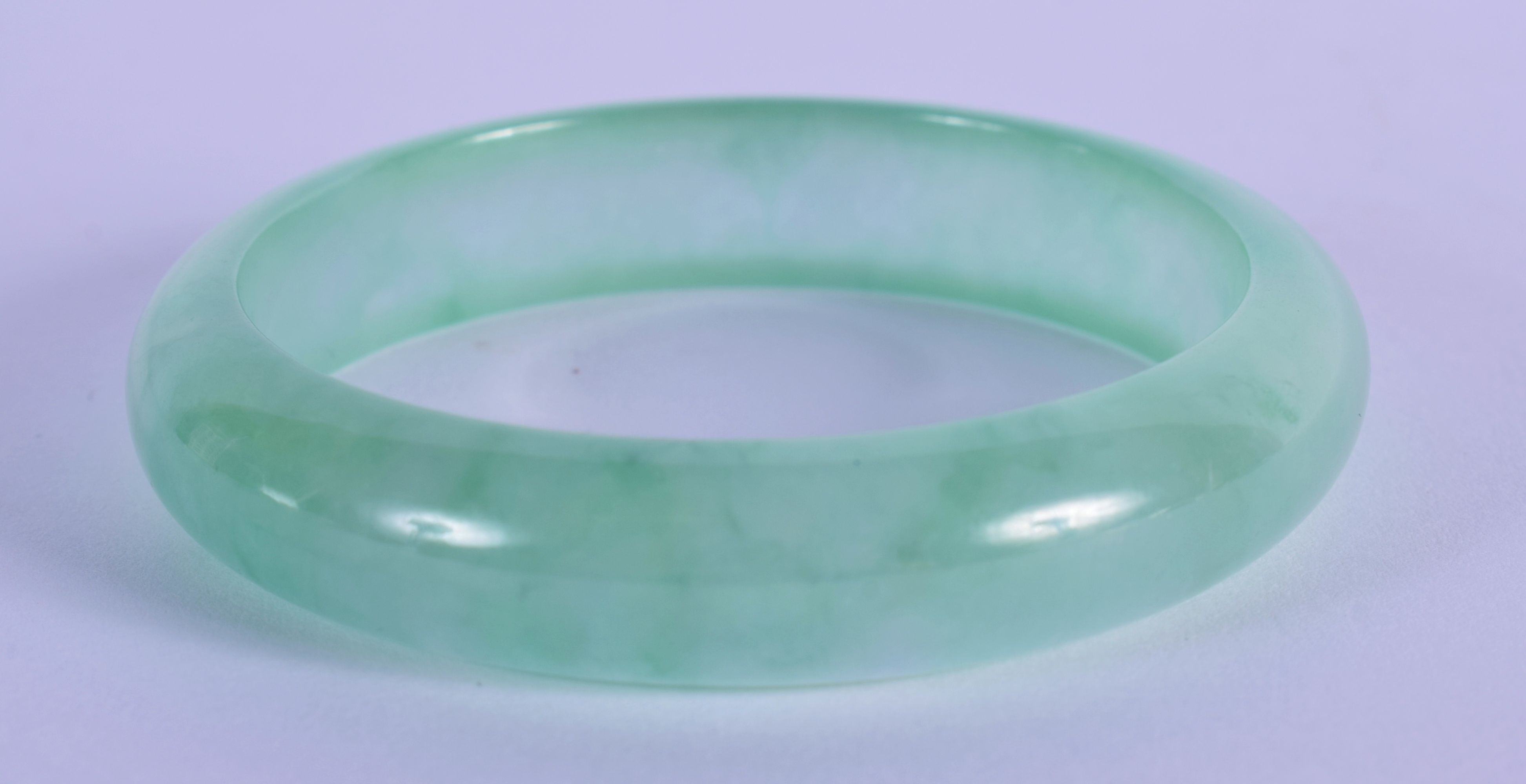 A 20TH CENTURY CHINESE CARVED ICY JADE BANGLE . 7cm Diameter - Image 2 of 3