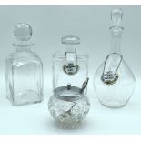 A Kosta Boda glass decanter together with two other decanters, porcelain labels and a lidded jar. 28