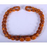 AN EARLY 20TH CENTURY EUROPEAN ORANGE AMBER NECKLACE of graduated form. 37 grams. 76 cm long, larges