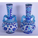 A PAIR OF LATE 19TH CENTURY PERSIAN TWIN HANDLED FAIENCE VASES painted with flowers. 26 cm high.