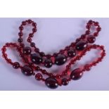 A PAIR OF ART DECO CHERRY AMBER TYPE NECKLACES. 260 grams. 68 cm long, largest bead 4.5 cm x 2.75 cm