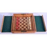 AN ANTIQUE CARVED AND STAINED BONE TRAVELLING CHESS SET with folding board. Largest 1.5 cm high. (qt