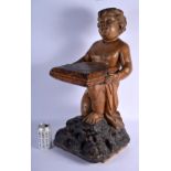 AN 18TH/19TH CENTURY EUROPEAN CARVED WOOD FIGURE OF A KNEELING BOY modelled holding a pillow decorat