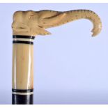 A 19TH CENTURY ANGLO INDIAN CARVED IVORY AND HARDWOOD WALKING CANE formed as an elephant. 90 cm long
