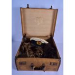 A VINTAGE SUITCASE containing a military hat, wigs etc. (qty)