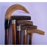 FOUR 19TH CENTURY CONTINENTAL CARVED RHINOCEROS HORN WALKING CANES together with another horn stick,