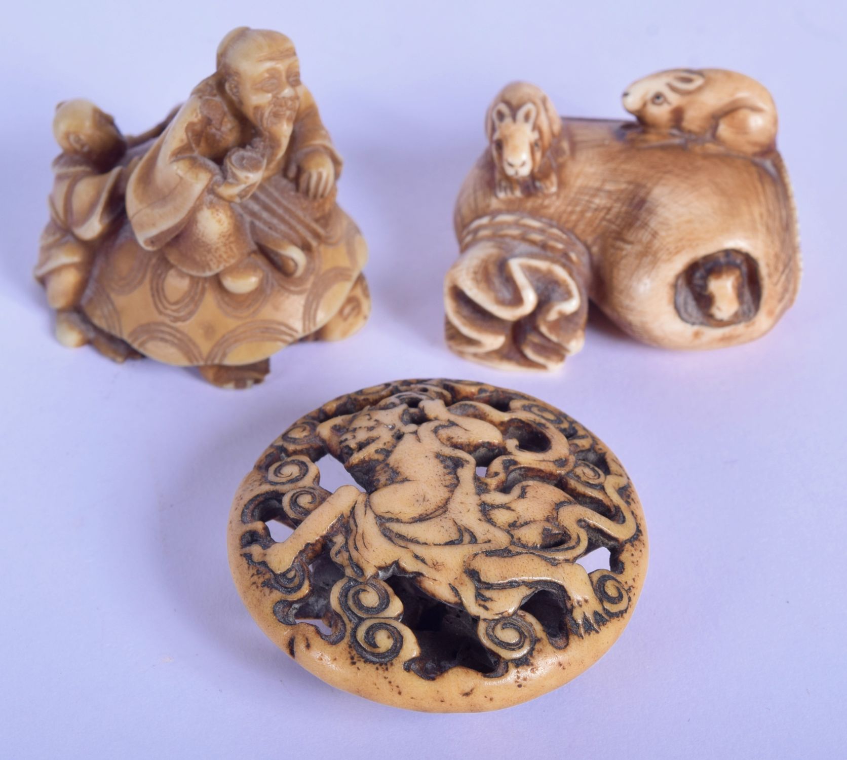 AN 18TH/19TH CENTURY JAPANESE EDO PERIOD CARVED STAG ANTLER MANJU NETSUKE together with a stone nets