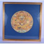 A 19TH CENTURY CHINESE FRAMED CIRCULAR SILKWORK ROUNDEL Qing, depicting a dragon upon a rich orange