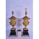 A LARGE PAIR OF 19TH CENTURY GILT BRONZE AND MARBLE TWIN HANDLED URNS AND COVERS upon black marble p