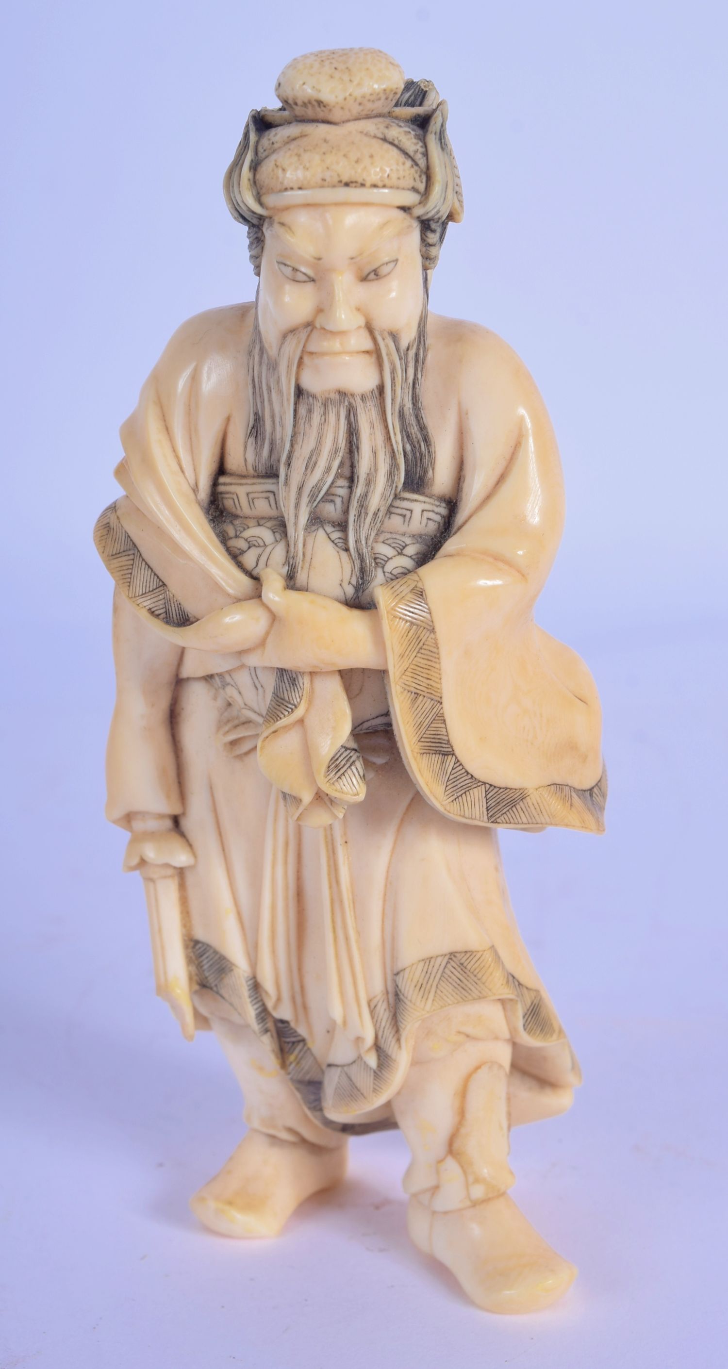 A 19TH CENTURY JAPANESE MEIJI PERIOD CARVED IVORY OKIMONO modelled as a warrior. 10 cm high.