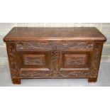 A LARGE 18TH /19TH CENTURY CARVED ANTIQUE LIDDED CHEST with flowers carved into panels. 71 x 131 x 5