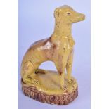 AN 18TH/19TH CENTURY CONTINENTAL YELLOW GLAZED POTTERY FOLK ART FIGURE OF A HOUND with brown glazed