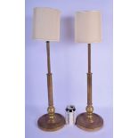 A PAIR OF EARLY 20TH CENTURY BRASS CANDLESTICKS converted to lamps. 65 cm high overall.