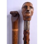 AN 18TH/19TH CENTURY CARVED FRUITWOOD WALKING CANE together with a similar later fist cane. Largest