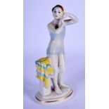 A RUSSIAN USSR PORCELAIN FIGURE OF A FEMALE SWIMMER modelled placing her swimming cap on. 17 cm high