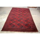 A FINE LARGE CONTINENTAL RICH RED GROUND RUG, finely decorated with black geometric styles and patte
