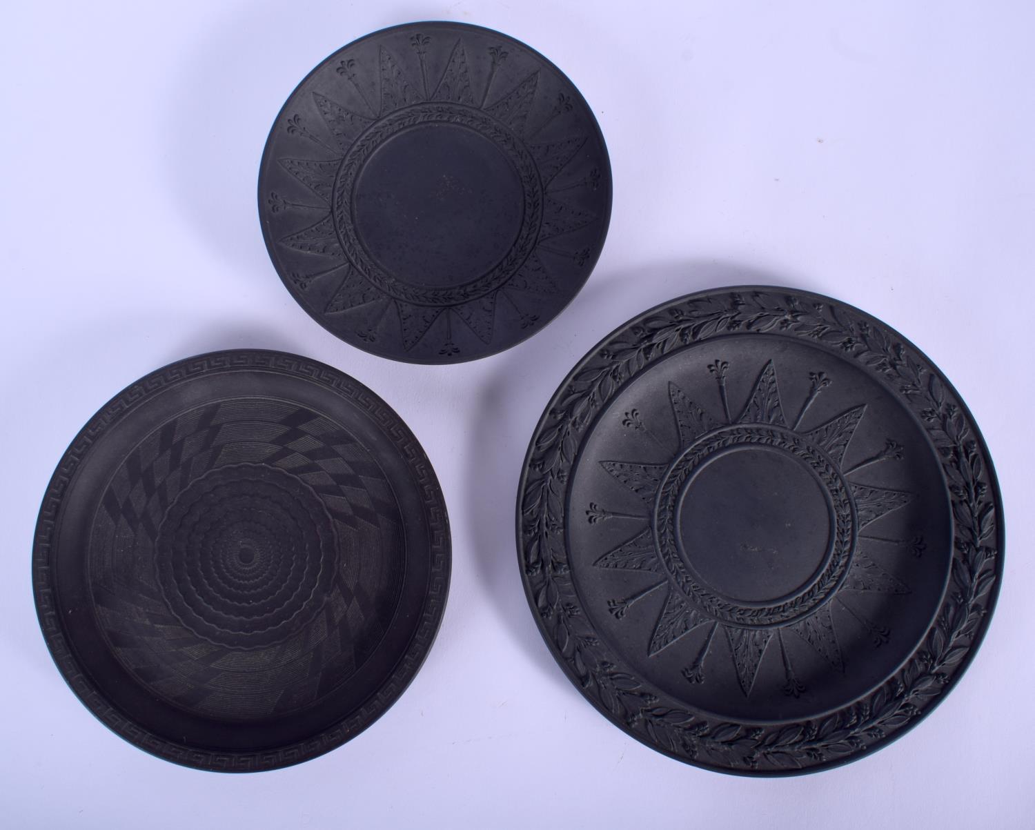 TWO 19TH CENTURY BLACK BASALT CIRCULAR PLATES one decorated with a star anthemion pattern, the other