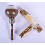 AN 18CT GOLD AND MOTHER OF PEARL CANE HANDLE together with a carved agate ball cane handle. Largest