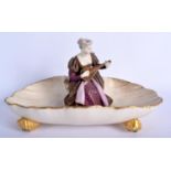Royal Worcester rare shell dish with four shell feet having a girl seated in the centre playing an i