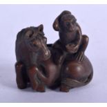 A JAPANESE WOOD NETSUKE IN FOR FORM OF A HORSE WITH A MONKEY ON ITS BACK. 4.4cm x 4.4cm, weight 24.