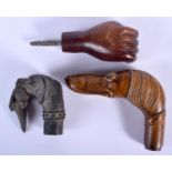 AN ANTIQUE CARVED TREEN DOG HEAD WALKING CANE HANDLE together with two others. Largest 13 cm x 8 cm.