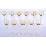 A SET OF ELEVEN STYLISH YELLOW AND CLEAR GLASS WINE GLASSES with facetted central stems. 19 cm high.