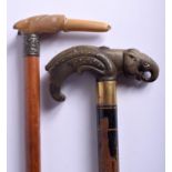 TWO 19TH CENTURY MIDDLE EASTERN CARVED RHINOCEROS HORN WALKING CANES with animal head terminals. Lar