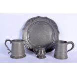 AN ANTIQUE PEWTER JUG together with two others and an trivet plate. Largest 19 cm wide. (4)