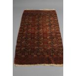 AN AFGHAN RUG, the madder field with three rows of linked quartered guls in ivory and navy blue,