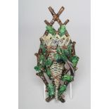 A CONTINENTAL MAJOLICA WALL POCKET, late 19th century, modelled as an exotic bird perched upon a