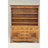A LATE GEORGIAN OAK DRESSER, early 19th century, the boarded rack with moulded cornice over frieze