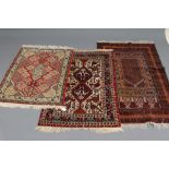 A PERSIAN TRIBAL SMALL RUG, the ivory and blue field with two linked navy blue guls and featuring