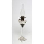AN EARLY VICTORIAN GLASS OIL LAMP, the panelled screw-in reservoir with gilt metal fittings