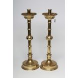 A LARGE PAIR OF ARTS AND CRAFTS BRASS CANDLESTICKS, the turned socket with moulded flared drip