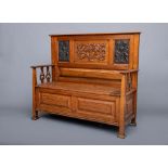 AN ARTS AND CRAFTS OAK BOX SETTLE, the raised panelled back with moulded top rail, central panel