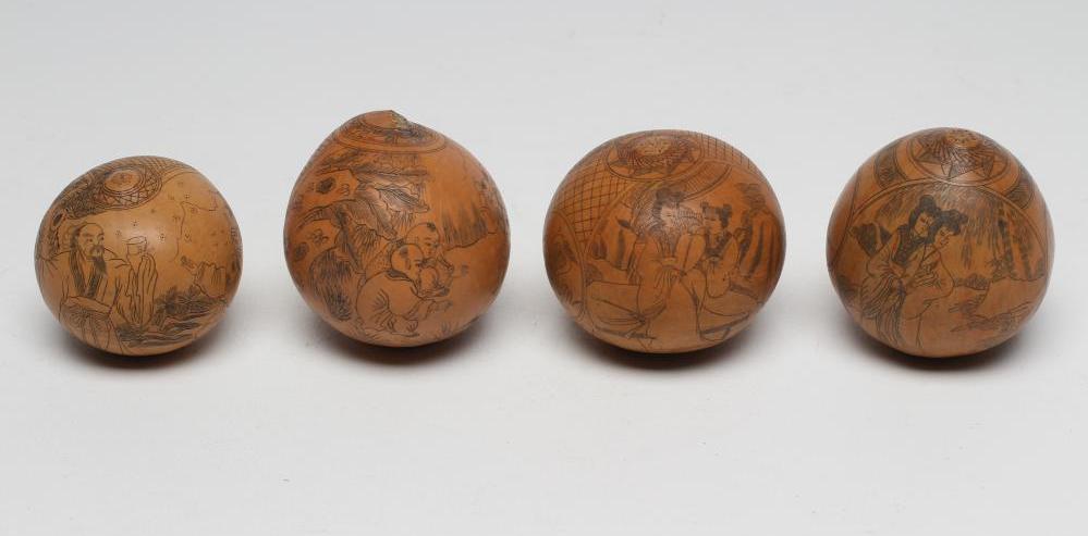 FOUR JAPANESE SEED PODS, late 19th century, each with black stained and engraved figures and