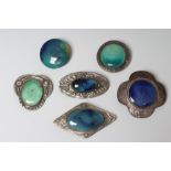 A COLLECTION OF FIVE RUSKIN TYPE ARTS AND CRAFTS PEWTER BROOCHES, large oval panel 1 3/4" wide,