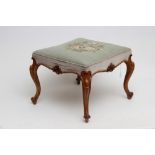 A VICTORIAN WALNUT DRESSING STOOL of long form with overstuffed seat in pale green floral gros