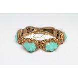 A CHINESE FILIGREE GILT BRACELET inset with four irregular polished green hardstones in cushion